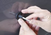 Användare applicerar lim med varmlimpistol för buckelreparation.