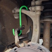 Bromsok upphängt säkert med grön S-krok under service